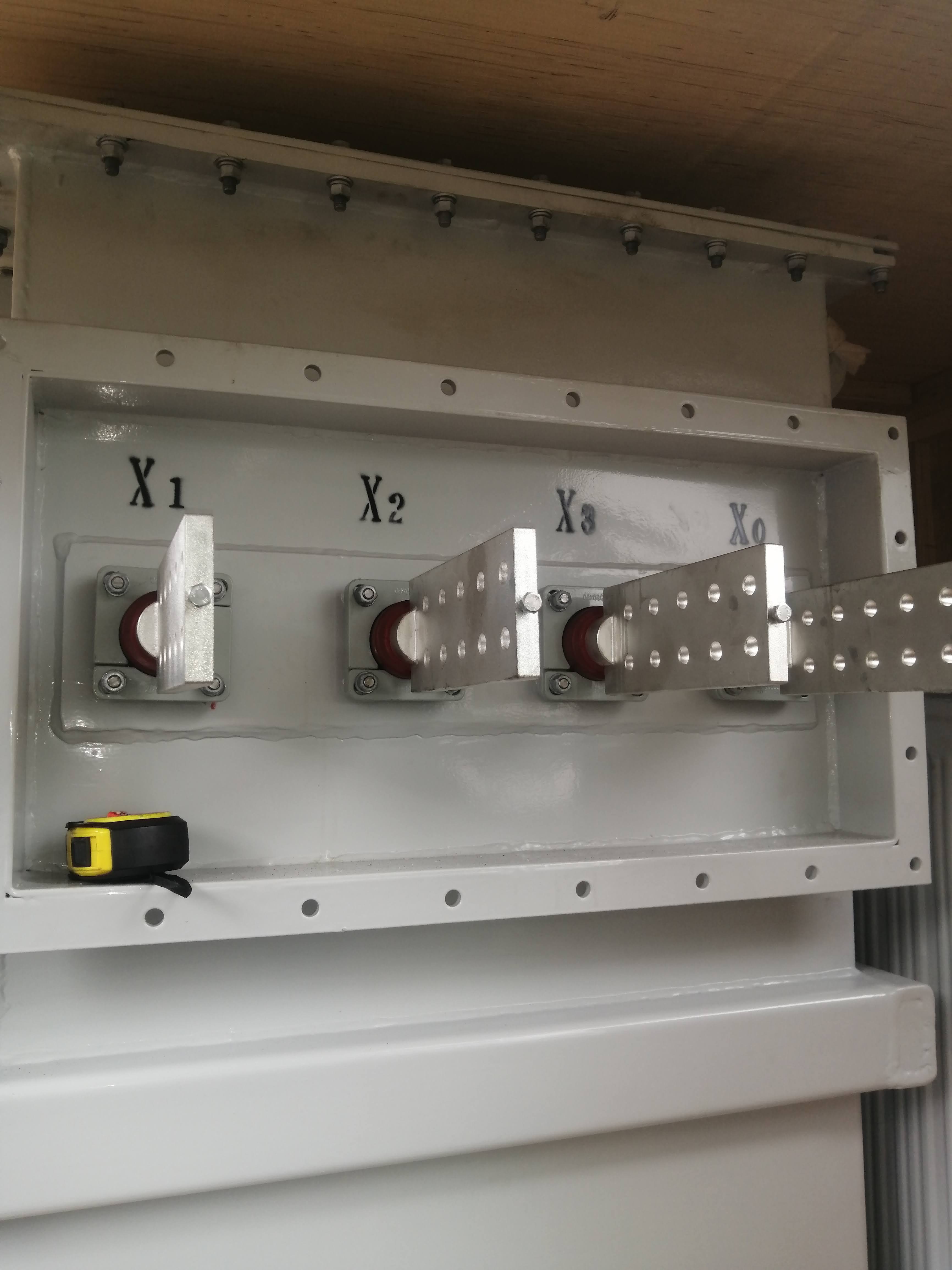 Four electrical terminals labeled X1, X2, X3, and X0 inside a gray metal enclosure.