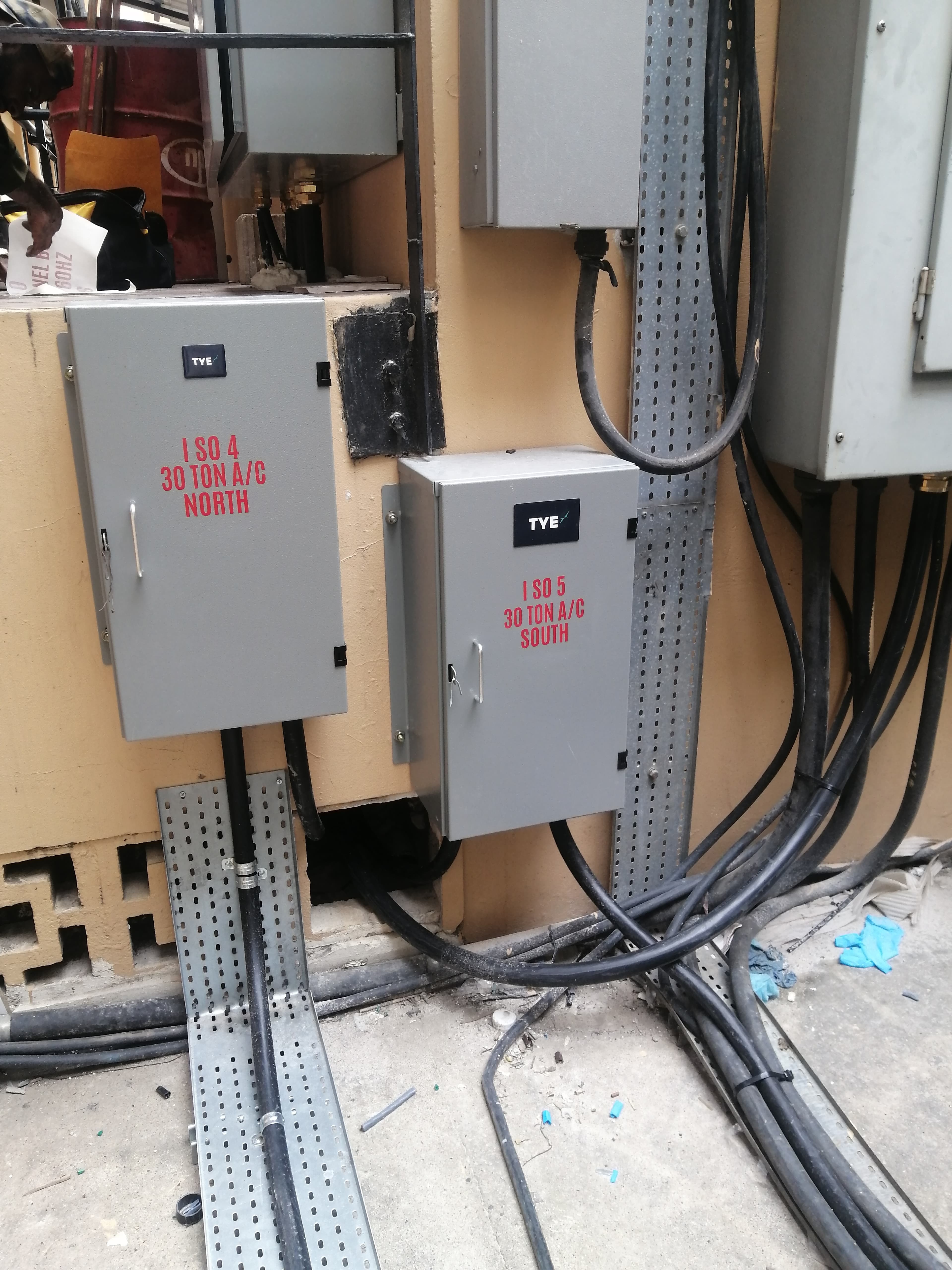 Two grey electrical boxes for North and South 30-ton A/C units with thick cables.